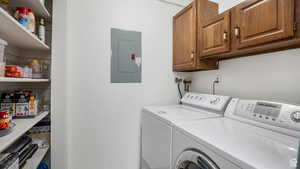 Laundry area with electric panel, independent washer and dryer, and cabinet space