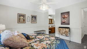 Carpeted bedroom with ceiling fan and ensuite bath