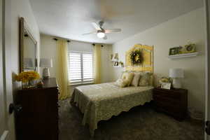 Bedroom with dark carpet and a ceiling fan