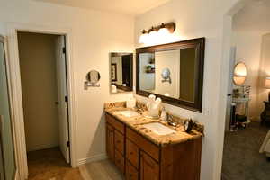 Full bath featuring double vanity and baseboards