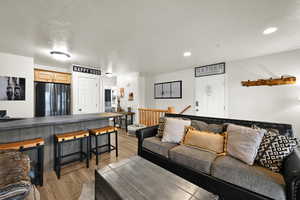 Living room with light wood finished floors and recessed lighting