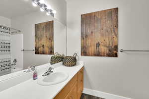 Full bath with vanity, shower / tub combo, and dark wood-style flooring