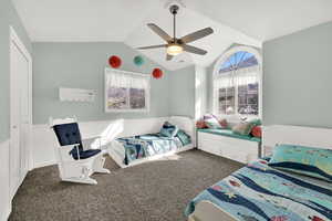 Bedroom with dark colored carpet, a ceiling fan, and a closet