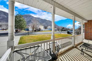 Covered porch featuring a mountain view and a residential view