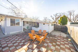 Rear view of house featuring a fenced backyard, a patio area, and a chimney