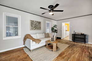 Living room featuring wood-type flooring, radiator heating unit, and ceiling fan