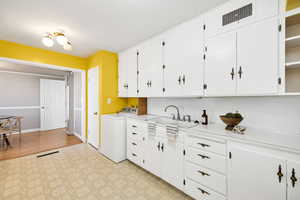 Kitchen featuring white cabinets, light countertops, and light floors