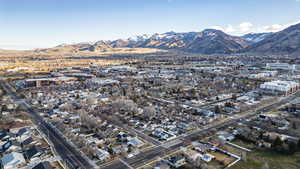 Aerial overview of property's location featuring a mountainous background and nearby suburban area