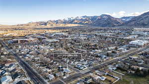 Aerial view of property and surrounding area with mountains and nearby suburban area