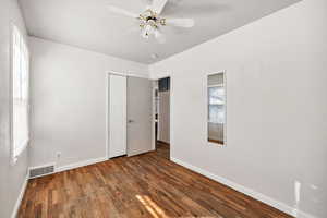 Unfurnished bedroom featuring dark wood finished floors, a ceiling fan, and a closet