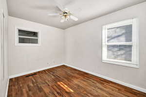 Empty room featuring dark wood finished floors and a ceiling fan