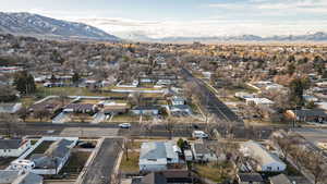 Aerial view of property and surrounding area featuring a mountain backdrop and nearby suburban area