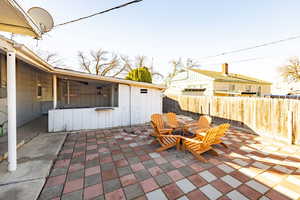 Fenced backyard with an outdoor fire pit and a patio area