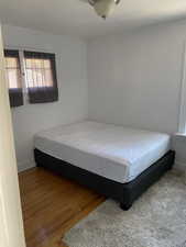 Bedroom featuring wood finished floors and baseboards