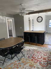 Dining room featuring light wood-type flooring, a textured ceiling, and a ceiling fan