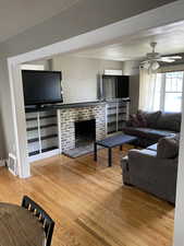 Living area with a textured ceiling, light wood finished floors, and ceiling fan