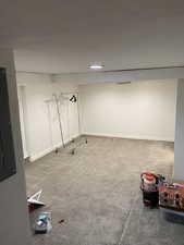 Finished basement with baseboards and carpet floors