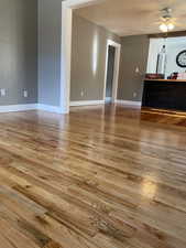 Unfurnished living room with ceiling fan and light wood-style floors