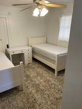 Bedroom with a ceiling fan and light carpet
