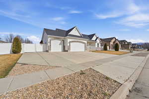 Single story home featuring an attached garage, a gate, and concrete driveway