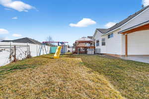 Fenced backyard with a playground and a gazebo