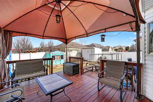Wooden deck featuring a shed, a residential view, and a fenced backyard