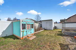 View of shed with a fenced backyard and a garden