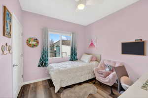 Bedroom featuring a custom closet, laminate flooring and ceiling fan