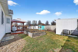 Fenced yard featuring a garden, a gazebo, and a wooden deck