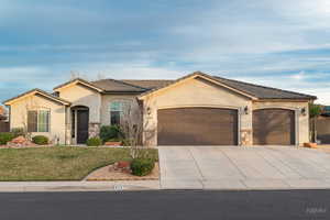 View of front of house featuring stone siding, a garage, concrete driveway, and stucco siding