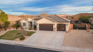 View of front of house featuring a garage, driveway, stucco siding, and stone siding