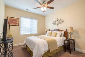 Bedroom featuring a ceiling fan and dark colored carpet