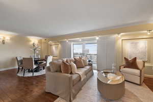 Living area with hardwood / wood-style flooring and ornamental molding