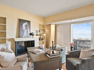 Living area featuring built in features, a fireplace, and wood finished floors