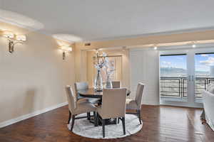 Dining area with crown molding, dark wood-style flooring, and a mountain view
