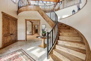 Entryway with stone tile flooring, a high ceiling, and recessed lighting