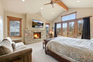 Bedroom featuring carpet floors, a stone fireplace, recessed lighting, multiple windows, and a ceiling fan
