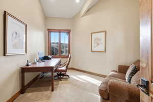 Home office featuring light colored carpet and baseboards