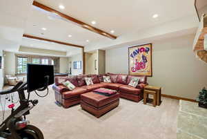 Living area featuring beamed ceiling, recessed lighting, and light carpet