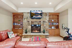 Living room with a stone fireplace and built in shelves