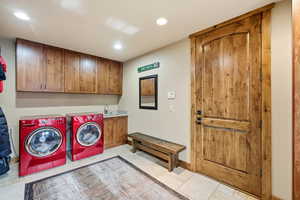 Laundry room with washing machine and dryer, cabinet space, and recessed lighting