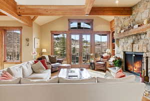 Living room featuring french doors, a fireplace, and lofted ceiling