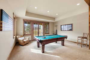 Rec room featuring pool table, french doors, light colored carpet, a raised ceiling, and recessed lighting