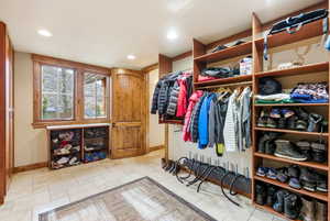 Walk in closet with stone tile flooring
