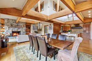 Dining room with a fireplace, light wood-type flooring, recessed lighting, beamed ceiling, and built in shelves