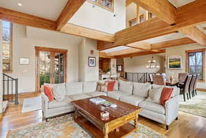 Living room with hardwood / wood-style flooring, french doors, and beam ceiling
