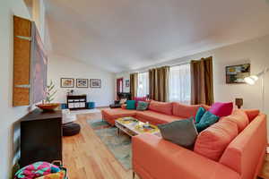 Living room featuring light wood-type flooring and lofted ceiling
