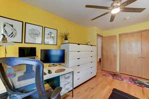 Office space with light wood-style flooring and ceiling fan