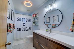 Full bath with vanity, light tile patterned flooring, and shower / bath combo with shower curtain
