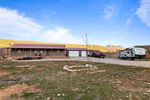 View of front of property with a mountain view, driveway, a porch, and a metal roof